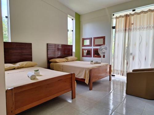 um quarto com 2 camas e uma janela em Casa de Campo con Piscina em Tingo María