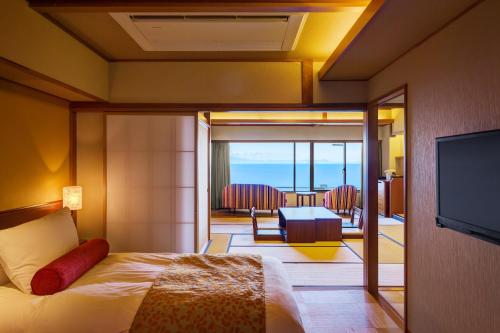 a hotel room with a bed and a television at 焼津グランドホテル in Hanazawa