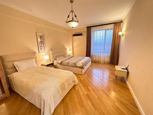 - une chambre avec 2 lits et une grande fenêtre dans l'établissement Rustaveli Luxe Premium Downtown Apartment, à Tbilissi