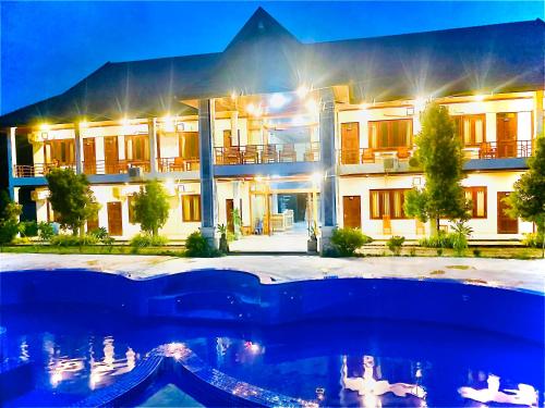 a hotel with a swimming pool in front of a building at Garden Resort in Vang Vieng