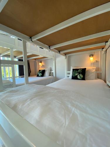 a large white bed with two pillows on it at Khaolak Mind Home Hostel in Khao Lak