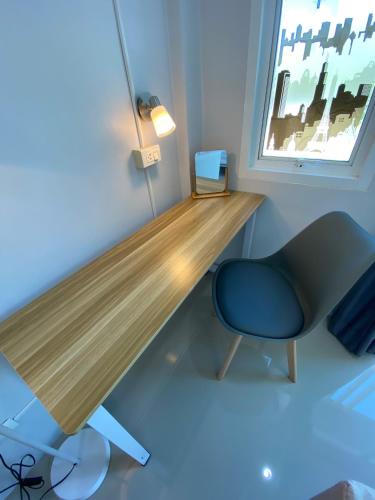 a room with a desk and a chair and a window at Khaolak Mind Home Hostel in Khao Lak
