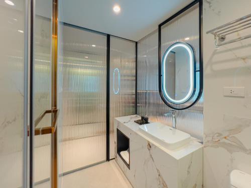 y baño con lavabo y espejo. en Cha Chiangmai Luxury, en Chiang Mai