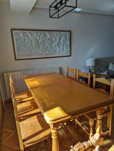 a wooden table and chairs in a room at Piso Grande La Viña in Biescas