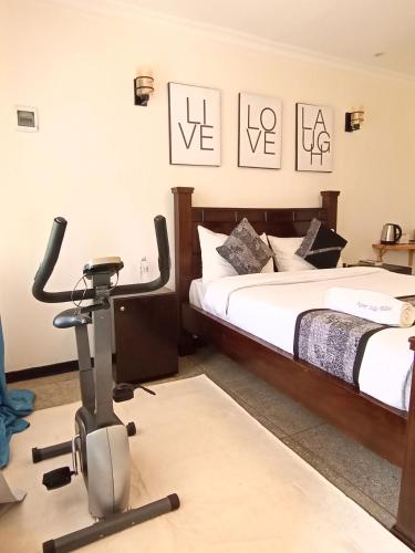 a room with two beds and a exercise bike at Riverside 001 in Nanyuki