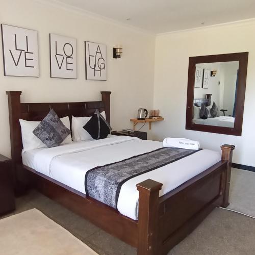a bedroom with a large bed and a mirror at Riverside 001 in Nanyuki