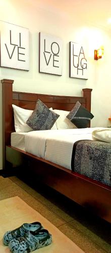 - une chambre dotée d'un lit avec 3 photos sur le mur dans l'établissement Riverside 001, à Nanyuki
