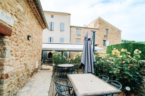 a patio with a table and an umbrella at Auberge de l'Abbaye Cruis in Cruis