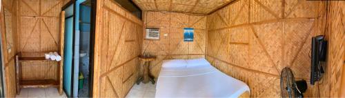 Habitación con vistas al interior y baño pequeño con paredes de madera. en Bamboo House Beach Lodge & Restaurant en Puerto Galera