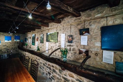 a room with a stone wall with a table and chairs at Auberge de l'Abbaye Cruis in Cruis