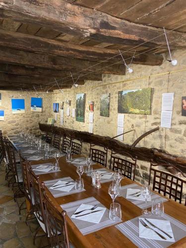 une grande salle à manger avec des tables et des chaises en bois dans l'établissement Auberge de l'Abbaye Cruis, à Cruis