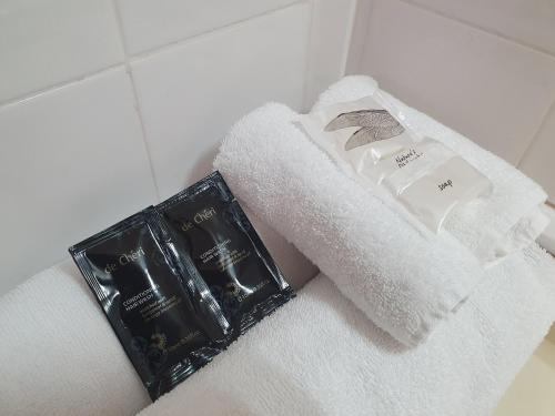 a pile of towels and a book on a bathroom counter at Ascot Epsom Motel in Auckland