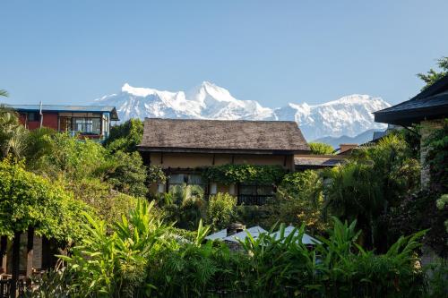 a house with a mountain in the background at Temple Tree Resort & Spa, Pokhara in Pokhara