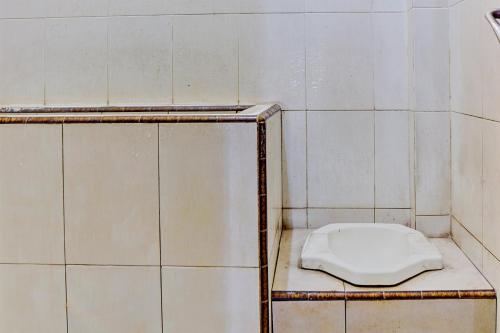 eine weiße Toilette auf einem Regal im Badezimmer in der Unterkunft OYO 93108 Homestay H Syarif Syariah – RA Kartini in Gresik