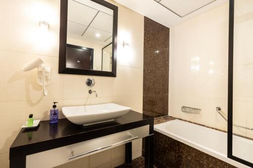 a bathroom with a sink and a tub and a mirror at BEAUTIFUL HUGE 2 BED ROOM APARTMENT in Dubai