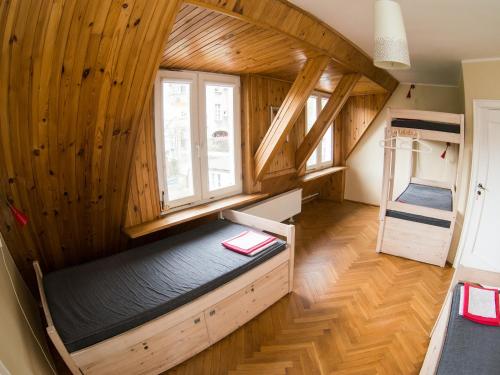 a room with a bed in a room with wooden walls at Hostelino in Sopot