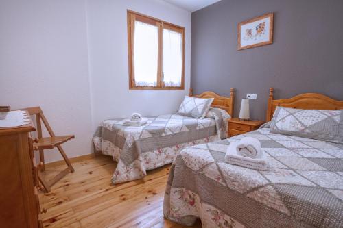 a small bedroom with two beds and a window at LA GINESTA 2, Apartaments de muntanya in Taull
