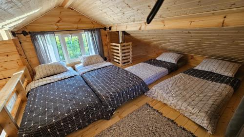 - une chambre avec 2 lits dans une cabane en rondins dans l'établissement Metsavahi puhketalu, 