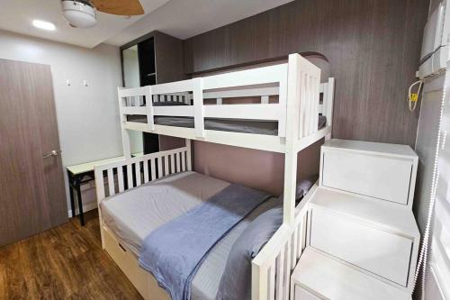 a bedroom with two bunk beds in a room at Stylish 2 Bedroom Condo Near BGC and Airport with Fast WiFi in Manila