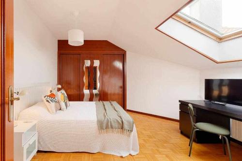 a bedroom with a bed and a desk and a television at Coto Salinas Apartamento in Salinas