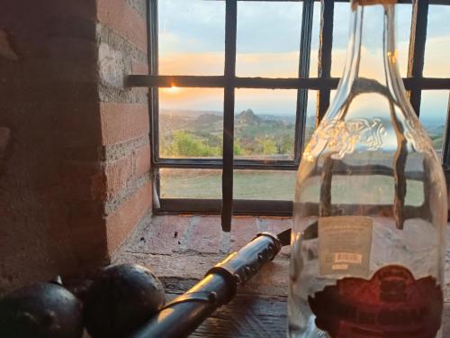 a glass bottle sitting on a table in front of a window at Fattoria Branciana in Rossena