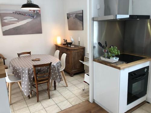 a kitchen and dining room with a table and a table and chairs at Maison Plage à 50m, Centre Ville avec sa cabine de plage in Le Crotoy