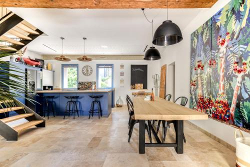 cocina y comedor con una gran mesa de madera en La Remise des Amis - Maison rénovée au calme, en Peyriac-de-Mer