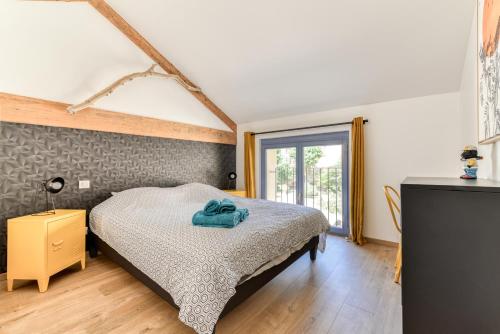 um quarto com uma cama e uma janela em La Remise des Amis - Maison rénovée au calme em Peyriac-de-Mer