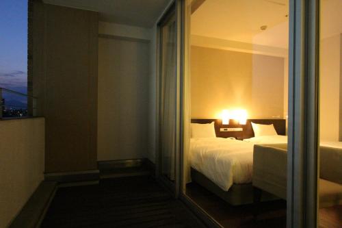 a hotel room with a bed and a window at KOKO HOTEL Sendai Kotodai Park in Sendai