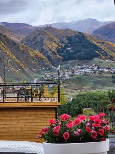 a vase of flowers sitting on a balcony with mountains at Magic Hut_Kazbegi in Kazbegi