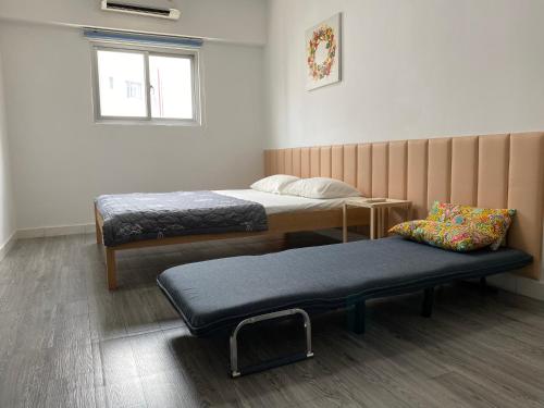 Zimmer mit 2 Betten, einer Bank und einem Fenster in der Unterkunft Modern 1 bedroom apartment - C' House in Ho-Chi-Minh-Stadt