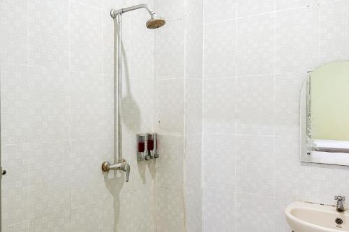 y baño con ducha y puerta de cristal. en Global Inn Syariah Mitra RedDoorz near Juanda T1 Airport 