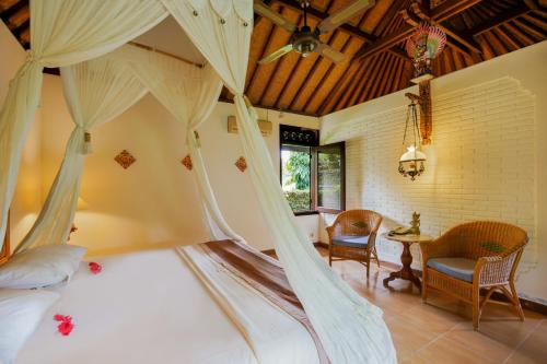 a bedroom with a bed with a canopy at Villa Chempaka in Ubud