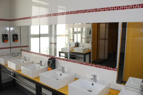 ein Badezimmer mit 3 Waschbecken und einem großen Spiegel in der Unterkunft Mola! Hostel Burgos in Burgos