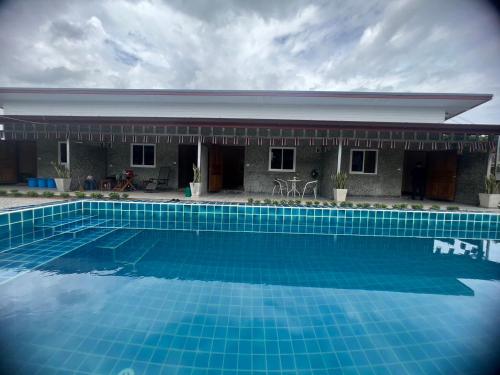 a swimming pool in front of a house at PePi-Resort in Chiang Rai