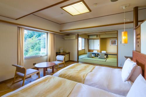 a bedroom with a bed and a table and a mirror at 焼津グランドホテル in Hanazawa
