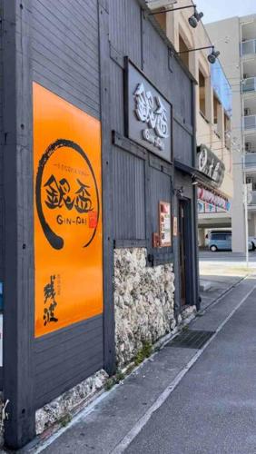 an orange sign on the side of a building at 【MEMS】1人から貸切OK!駐車場1台付き!那覇空港から車で13分！ in Takara