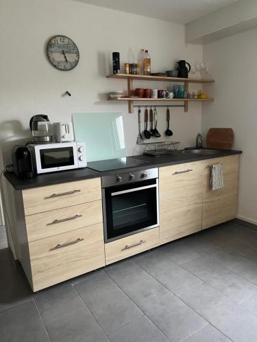 a kitchen with a stove and a microwave at Gemütliches Apartment nahe Porsche in Weissach