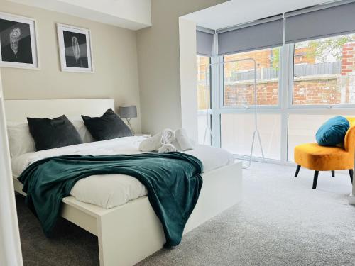 a white bedroom with a bed and a chair at Ground Floor 1-Bed Flat in Newmarket - WiFi Sleeps 3 Guests in Newmarket