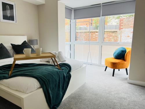 a bedroom with a bed and a chair and a window at Brand New 1 Bed with Sofabed, Private Patio & Electric Parking Bay, 5min Walk to Racing & Main Strip LONG STAY WORK CONTRACTOR LEISURE - AMBER in Newmarket