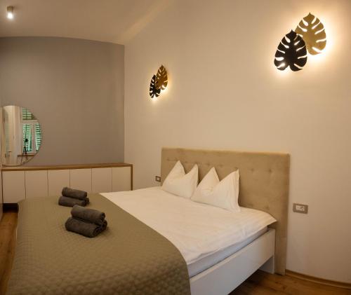 a bedroom with a bed and two lights on the wall at Stay & Heal Apartman in Rogaška Slatina