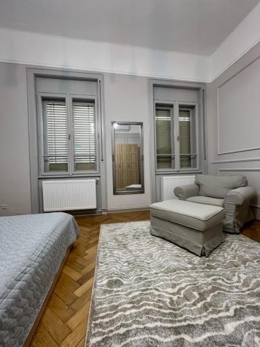 a bedroom with a bed and a couch and a chair at Barty downtown apart 2 in Timişoara