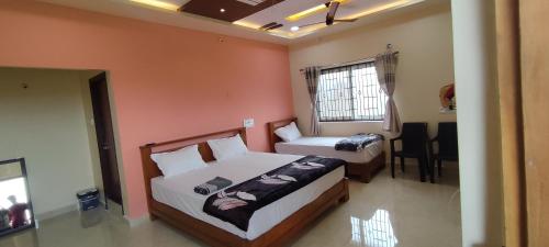 亨比的住宿－Mamatha Guest inn，一间卧室设有两张床和窗户。