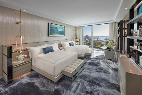 a living room with a white bed and a couch at Crown Towers Sydney in Sydney