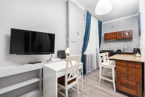 uma sala de estar com uma secretária, uma televisão e uma cozinha em Elektoralna 19 by Homeprime em Varsóvia