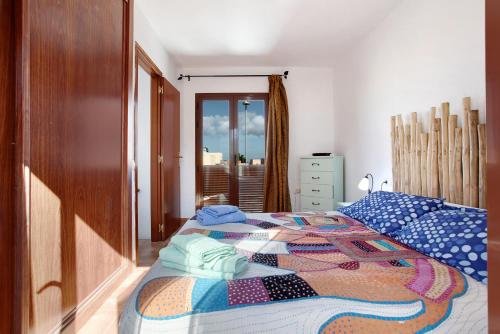 a bedroom with a bed with a quilt on it at Villa Charlotte in La Oliva