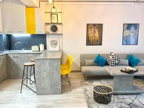 Il dispose d'une cuisine et d'un salon avec un canapé et une table. dans l'établissement Apartament Happy Sea View, à Mamaia Nord – Năvodari