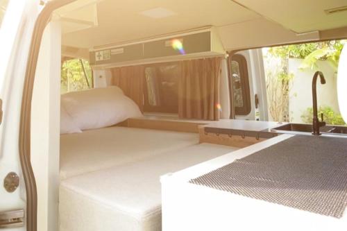 a white van with a bed and a bedroom at Campervan Bali Rental in Dalung