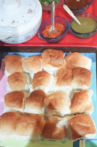 a tray of buns with soup and bowls of food at Seaswan resort in Alibaug
