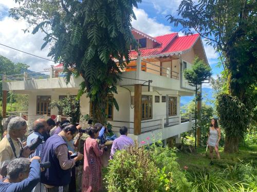 a group of people standing in front of a house at Bloomfield Farmhouse and Eco-Resort in Darjeeling